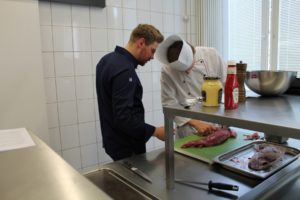 Benedikt Holzhinrich (links) schaute den Teilnehmern des Seminars beim Zubereiten des Rindfleischs genau auf die Finger. Foto: Köcheclub Münsterland e.V.