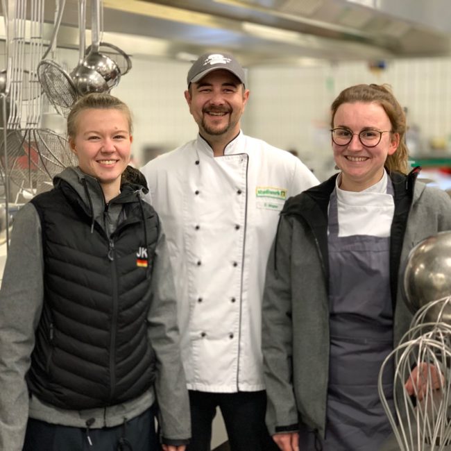 Küchenchef David Wagner (Mitte) vom Studiwerk freut sich über den Teambesuch (im Bild Jennifer Klement und Lena Schmitz vom Junior Team). Foto: VKD