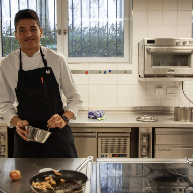 Koch-Azubis Tomas Njie während des Praxisunterrichts in der Frankfurter Bergiusschule. Foto: VKD