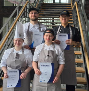 Die vier strahlenden Finalteilnehmenden des Berufs Koch/Köchin am Ende des Wettbewerbs.